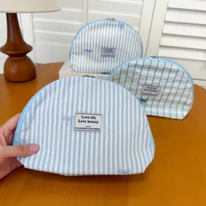 Blue striped cosmetic bag with cute embroidered bow, large capacity portable shell makeup pouch.