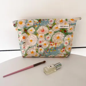 Detailed view of the oil painting floral cosmetic pouch with zipper and brand label.
