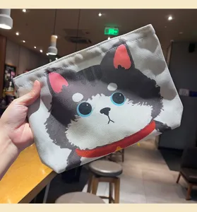 Vue détaillée de la trousse de maquillage en toile avec chien mignon et fermeture à glissière.
