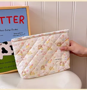 Cute quilted cosmetic bag featuring adorable cartoon bear and floral patterns for travel storage.
