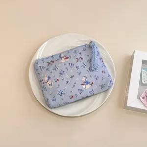 Detailed view of the cute blue rabbit print fabric coin purse, featuring a handy zipper and tassel.