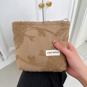 Detailed view of the cotton linen embroidered cosmetic bag with floral pattern and label.