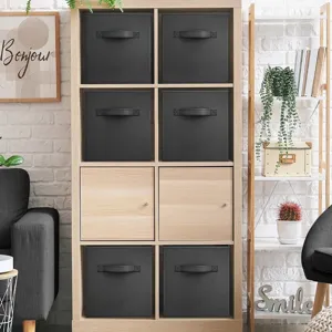 Foldable black fabric storage boxes displayed in a modern wooden cubby shelf for home organization.