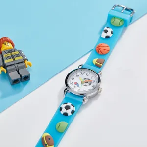 Children quartz watch detail featuring cute sports balls pattern on blue silicone strap.