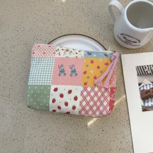 Cute patchwork cosmetic pouch with rabbit and strawberry prints, ideal travel makeup organizer.