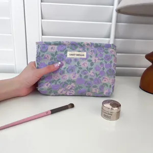 Vista dettagliata di una trousse per cosmetici floreale chic con eleganti toni viola e grigi.