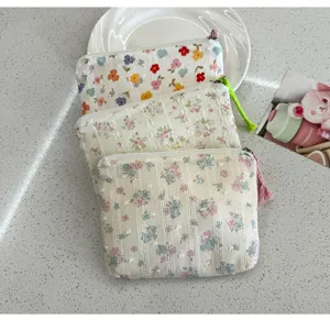 Floral fabric cosmetic pouch with zipper and tassel detail, portable cute makeup storage bag.