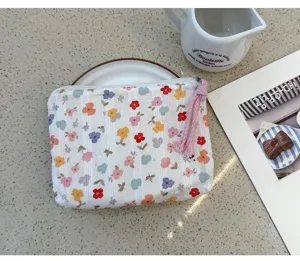 Compact floral cosmetic pouch with tassel zipper detail, ideal for daily makeup and small items.