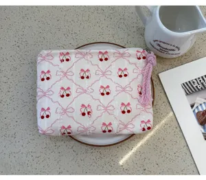 Portable cosmetic pouch with cute pink bow and cherry print, ideal for daily makeup storage.