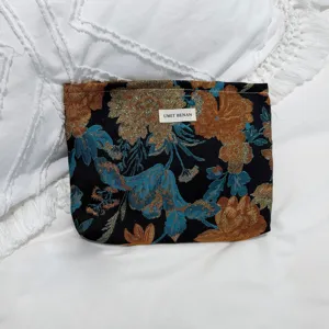 Vintage floral jacquard cosmetic pouch, elegant designer style travel makeup bag detail view.