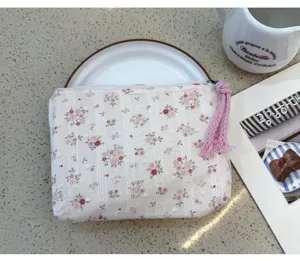 Floral fabric storage pouch detail, cute cosmetic bag with pink tassel zipper pull.
