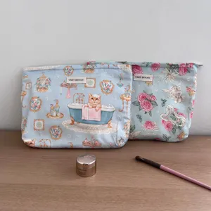Detailed view of large capacity floral cosmetic bag, cute cat print storage pouch for travel.