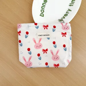 Canvas cosmetic bag featuring cute bunny and tulip print with zipper and brand label.