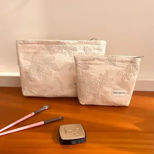 Canvas cosmetic bag set with elegant floral embroidery, portable makeup pouch and travel organizer.
