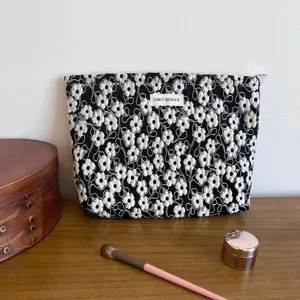 Detailed view of black 3d floral cosmetic bag fabric texture, embroidered flower detail close up.