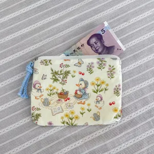 Detail view of cute duck pattern fabric coin purse zipper storage pouch with tassel