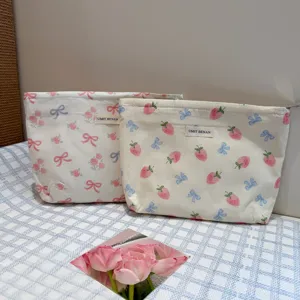 Detail shot of cute floral cosmetic storage bags featuring sweet strawberry and bow prints.