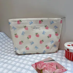 Cute strawberry bow makeup bag, portable travel cosmetic pouch with zipper and stylish label.
