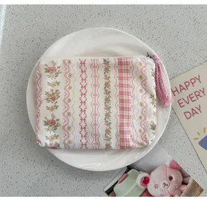 Mini floral checkered coin purse with pink tassel, portable fabric storage bag for items.