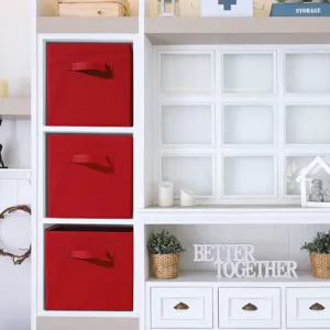 Detailed view of red foldable fabric storage cubes neatly organized in a white shelving unit.