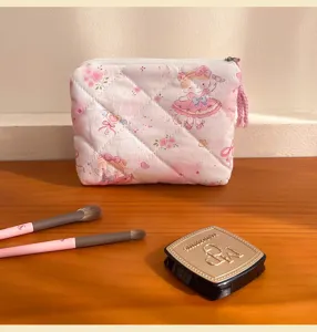 Close-up detail of the pink quilted makeup pouch with cute anime girl print and zipper.