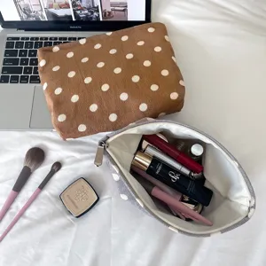 Detailed close-up of corduroy polka dot cosmetic storage pouch showing interior capacity.