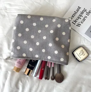 Detail view of grey polka dot cosmetic pouch, knitted makeup storage bag for daily use.