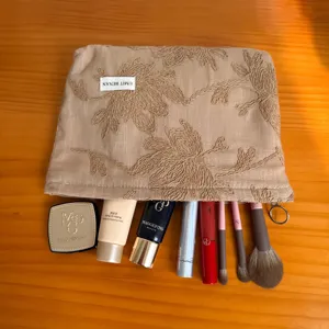 Detailed view of vintage linen embroidered floral cosmetic bag, large capacity portable clutch storage.