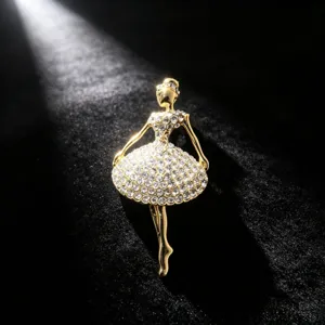 Close-up detail of a sparkling rhinestone ballerina brooch, exquisite gold tone fashion accessory.