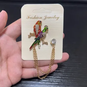 Close-up detail shot of the elegant crystal parrot brooch with a sparkling tassel chain.