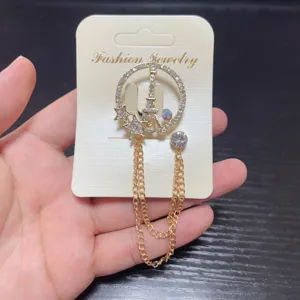 Exquisite rhinestone Eiffel Tower brooch with hanging chains, elegant lapel pin accessory.