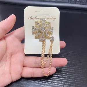 Rhinestone cross brooch detail, sparkling crystal and metal tassel chain, suit collar pin.
