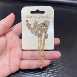 Elegant rhinestone tassel brooch featuring delicate floral design and shining golden chains.