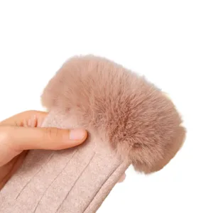 Gros plan de gants tricotés chauds d'hiver pour femmes avec manchette en fourrure pelucheuse.