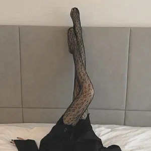 Detailed view of black leopard print fishnet tights, sheer mesh hosiery for women