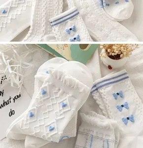 Chaussettes mi-hautes blanches de style japonais doux avec des nœuds bleus et des détails charmants.