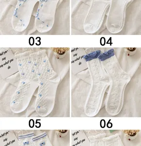 Vue détaillée de chaussettes blanches douces japonaises avec nœuds bleus et dentelle.