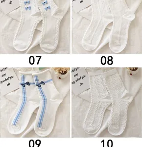 Vue détaillée de chaussettes blanches mi-mollet ornées de jolis nœuds et motifs.
