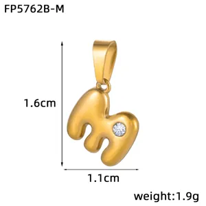 Detail view of the 3D bubble letter M pendant, 18k gold plated stainless steel with stone.