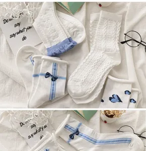 Vue détaillée de jolies chaussettes blanches et bleues avec nœud, dentelle et cœurs mignons.
