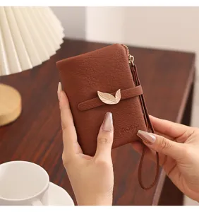 Brown leather short wallet detail view, featuring elegant leaf metal buckle and strap.