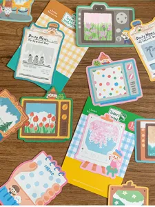 Close-up of cute oil pastel style sticky notes and memo pads with lovely illustrations for journaling.