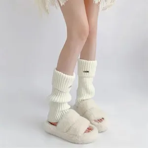 Nahaufnahme Detail von weißen klobigen Strick-Beinwärmern mit gemütlichen Winterschuhen.
