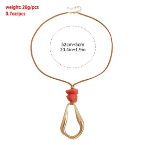 Adjustable velvet cord necklace with irregular geometric gold pendant and red stones.
