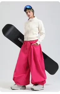Details of women's loose snowboard pants, windproof pink winter sports gear, high waist fit.