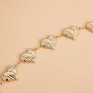 Primer plano de cinturón de cadena de corazón dorado, accesorio elegante de metal.
