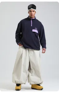 Professional oversized windproof waterproof ski pants matched with casual fleece pullover.