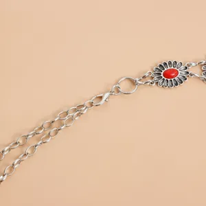 Close-up detail of vintage antique silver alloy waist chain with red floral stone pendant.