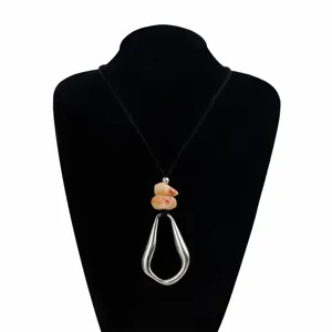 Detail view of the irregular geometric hollow pendant necklace with dyed stone beads and cord.