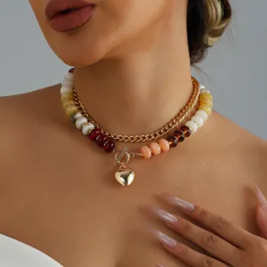 Detalle de primer plano de collar multicapa con cuentas de colores y cierre OT de corazón.
